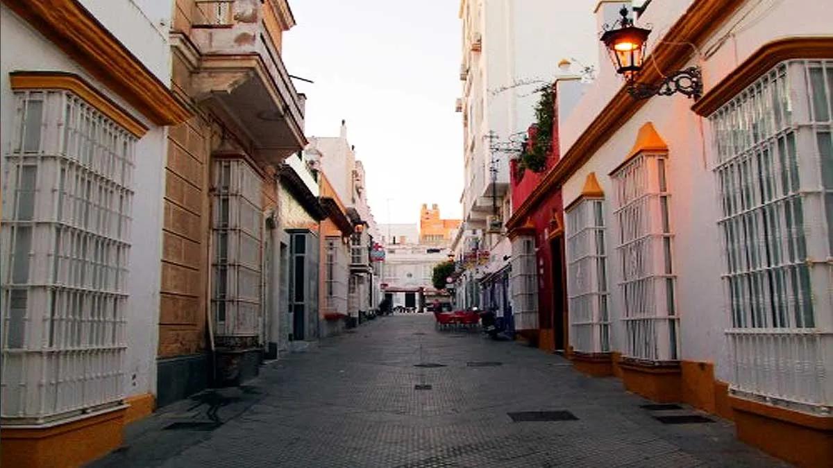 Calle Quevedo en San Fernando con casas encaladas y pintadas en las cornisas en color albero.