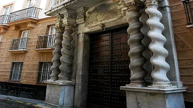 Fachada de la Casa de las Columnas, con columnas salomónicas y gran portón de madera.