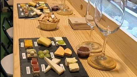 Imagen de la mesa de cata en La Cabra Loca: tablas de quesos variados, desde cuajadas lácticas hasta azules, listos para ser degustados con vino de la tierra.