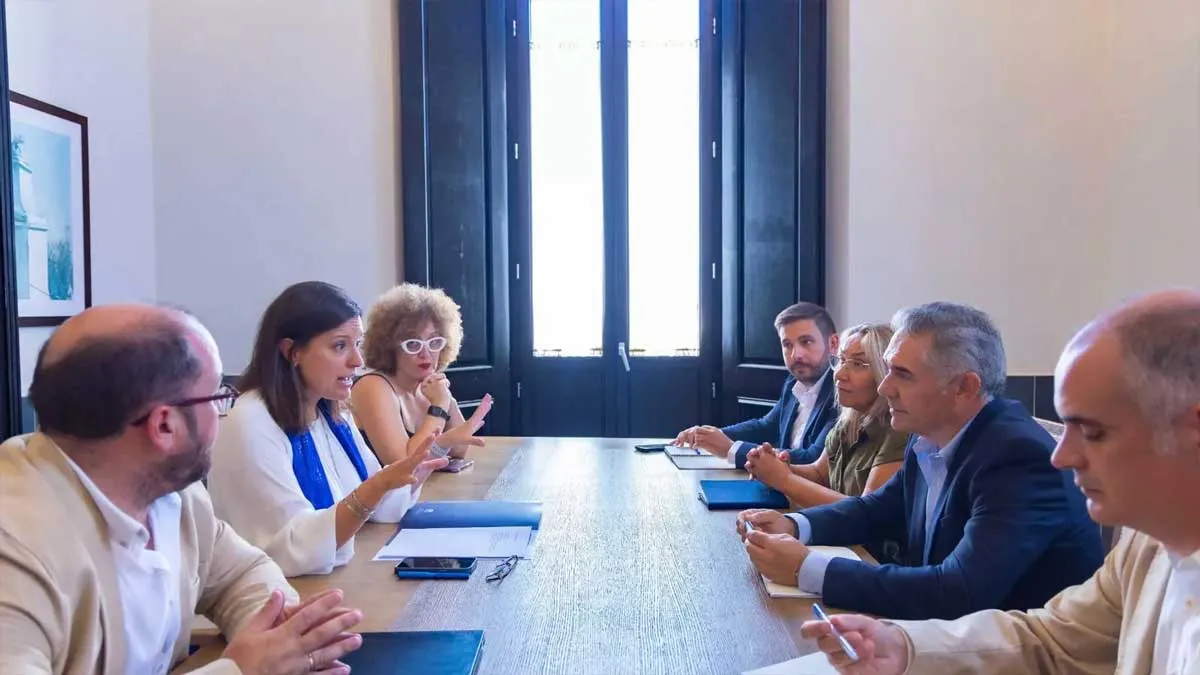 Patricia Cavada, de blanco, a la izquierda, conversa en la mesa de reuniones.
