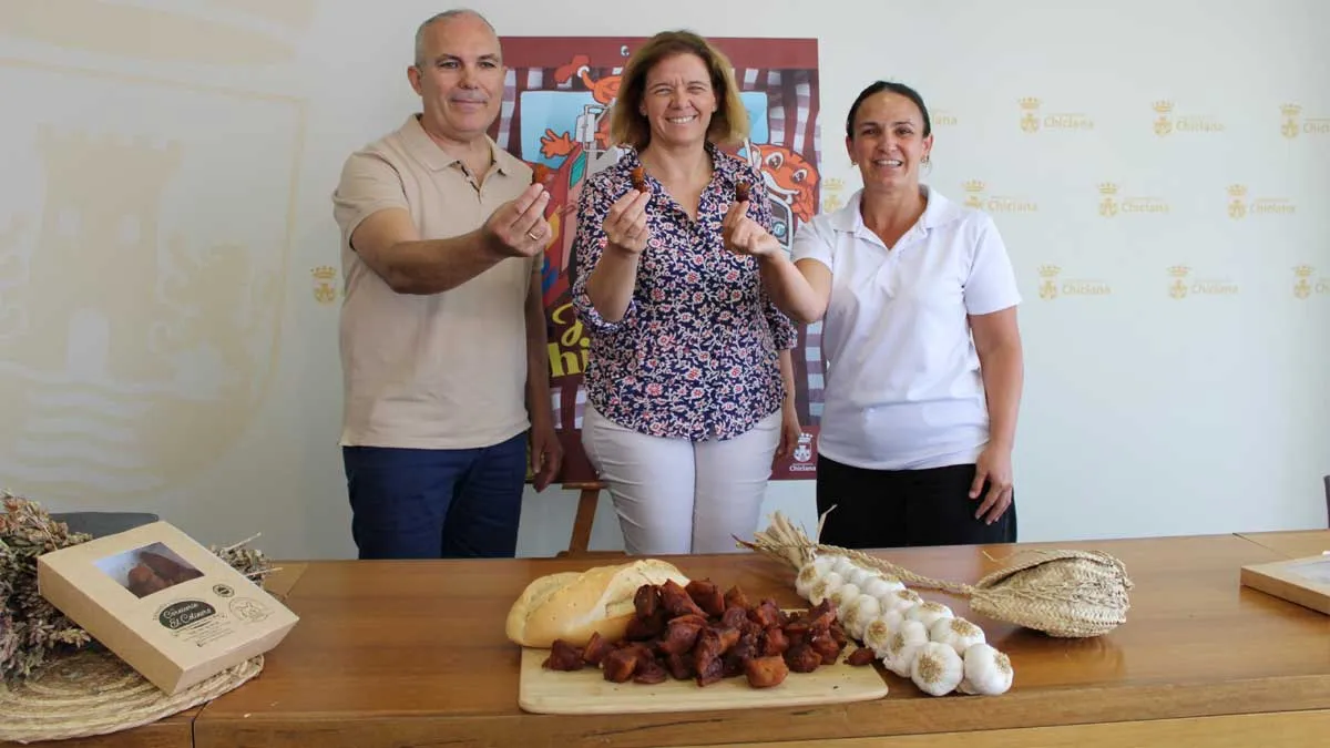 Productos para elaborar el chicharrón en primer término y Manuel Pérez junto a los organizadores.