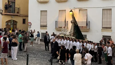 La Virgen de Cigarreras, portada en parihuela y rodeada de fieles, entra en la Plaza Fray Félix al atardecer, en el inicio de sus misiones jubilares por el casco histórico de Cádiz.