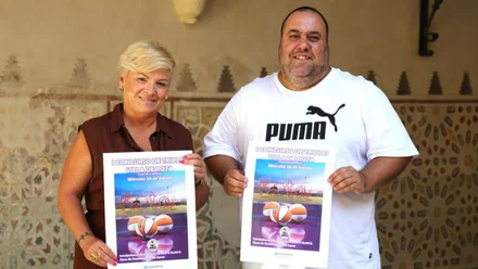Luisa Fernández, de marrón, y José Manuel Alcedo, de blanco, con el cartel del evento.