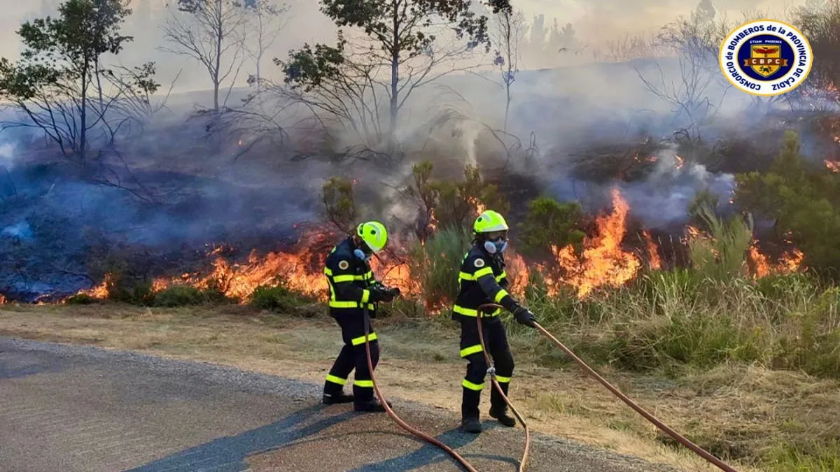 Dos bomberos de Cádiz sofocando las llamas en el monte gallego.