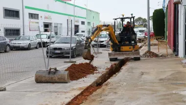 Maquinaria de obras abriendo una zanja en la calle del polígono industrial de Rota.