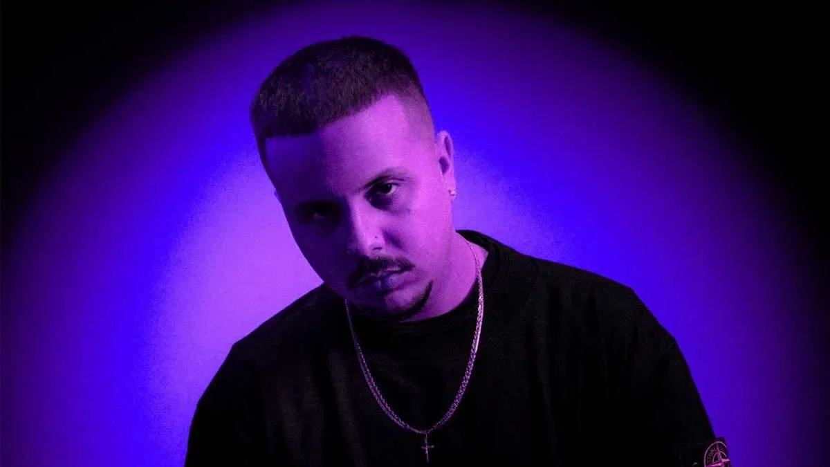 Cruz Cafuné con un fondo iluminado en azul.
