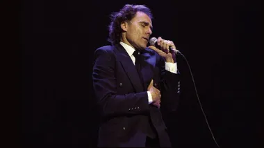 Diego Ramos caracterizado como Julio Iglesias, con traje y corbata en color negro y camisa blanca.