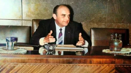 Emilio de la Cruz Hermosilla en traje de chaqueta y sentado en su despacho en madera.