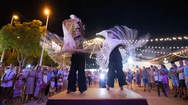 Chicas bailando flamenco con mantones en un tablao en la Feria de Trebujena.