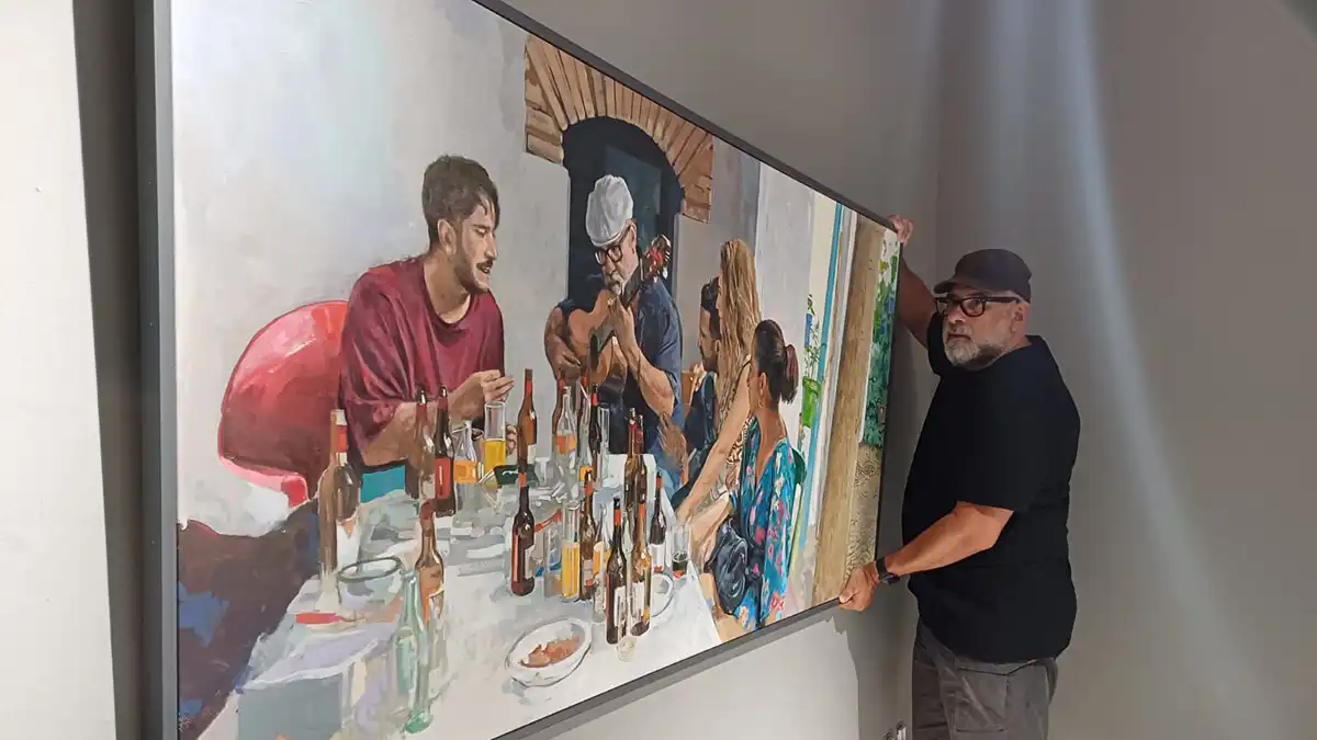 El pinto Fernando Beníntez Gabriel dando los últimos retoques a la instalación de los cuadros en su exposición 'Locus Amoenus'.