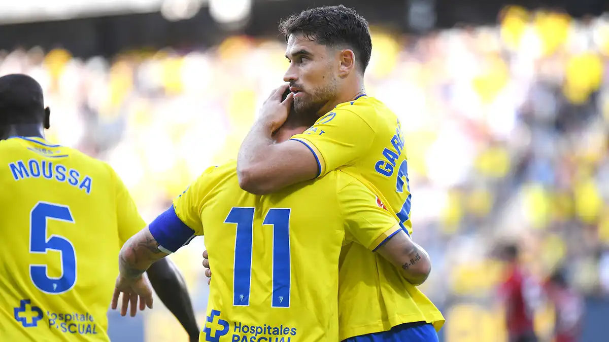 Álvaro García Pascual celebra un gol junto a Suso durante un partido del Cádiz CF, ambos con los brazos abiertos y gesto de alegría.
