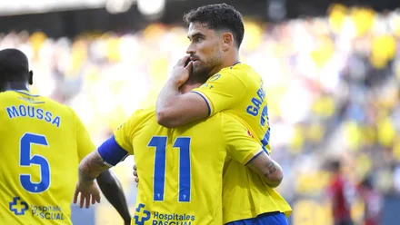 Álvaro García Pascual celebra un gol junto a Suso durante un partido del Cádiz CF, ambos con los brazos abiertos y gesto de alegría.