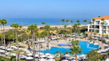 Hotel en Chiclana con la piscina y la playa a la vista.
