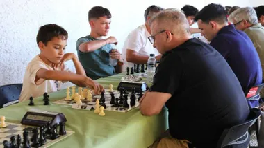 Un niño juega al ajedrez con un adulto.