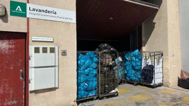 Puerta trasera del hospital Puerta del Mar, con cestas con bolsas azules.