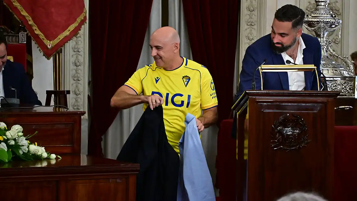 Madini con la cahqueta y su camisa en la mano tras quitarselas para llucir la camiseta del Cádiz CF.