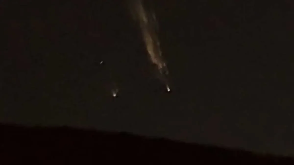 Bola de luz desintegrándose en la noche.