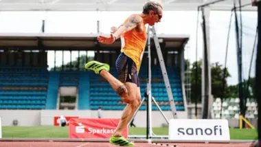 El atleta gaditano Miguel Ángel Muñoz cruza la línea de meta en Dresde durante una de las finales de los Juegos Mundiales de Trasplantados. Viste camiseta roja de España y muestra esfuerzo en el rostro mientras asegura una de las tres medallas que logró en la competición.