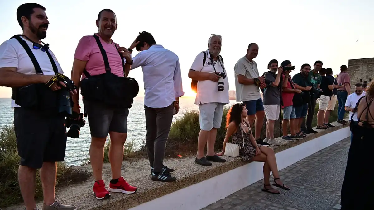 Numerosos fotógrafos subidos en la balasutrada al inicio del Paseo Marítimo de Cádiz.
