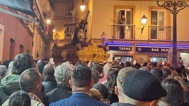 El Nazareno de Santa María, sobre su paso procesional con cirios encendidos, baja la Cuesta de Jabonería en dirección a la calle San Juan de Dios durante la Semana Santa de 2024 en Cádiz