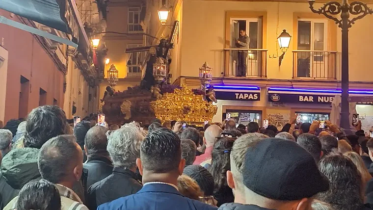 El Nazareno de Santa María, sobre su paso procesional con cirios encendidos, baja la Cuesta de Jabonería en dirección a la calle San Juan de Dios durante la Semana Santa de 2024 en Cádiz