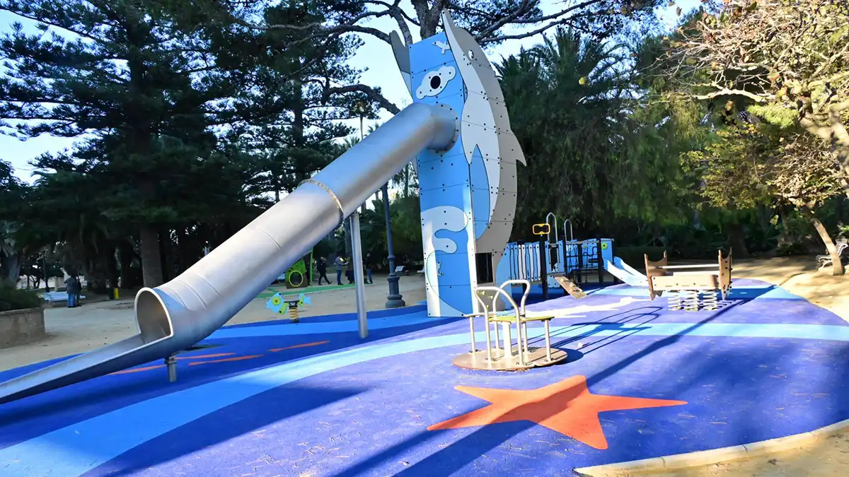 Parque infantil del Parque Genovés en Cádiz, con columpios y juegos rodeados de árboles