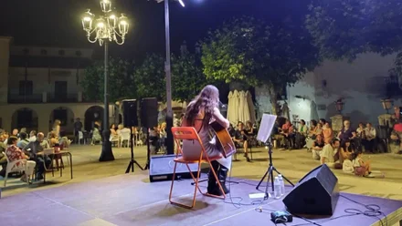 Chica tocando la guitarra en un escenario.