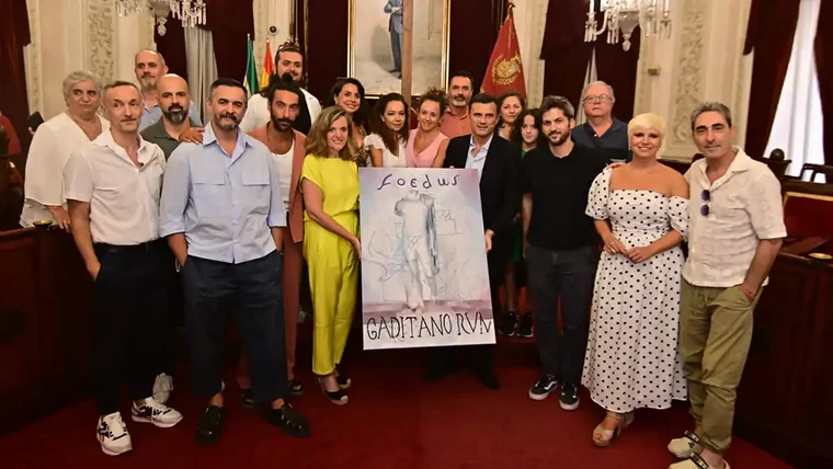 Imagen del Salón de Plenos del Ayuntamiento de Cádiz con el alcalde Bruno García y la concejala de Cultura, Maite González, posando junto a varios artistas y representantes del elenco de Foedus Gaditanorum durante la presentación del espectáculo central de Cádiz Romana.