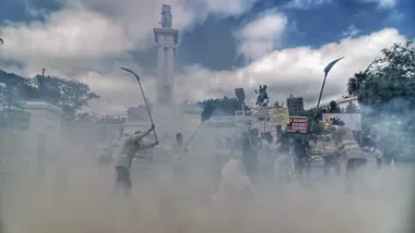 Manifestación de bomberos forestales del Plan Infoca en la Plaza de España de Cádiz. Se ven pancartas con lemas como “Se vende Infoca” y humo de colores frente al monumento de la Constitución de 1812.