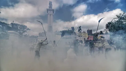 Manifestación de bomberos forestales del Plan Infoca en la Plaza de España de Cádiz. Se ven pancartas con lemas como “Se vende Infoca” y humo de colores frente al monumento de la Constitución de 1812.