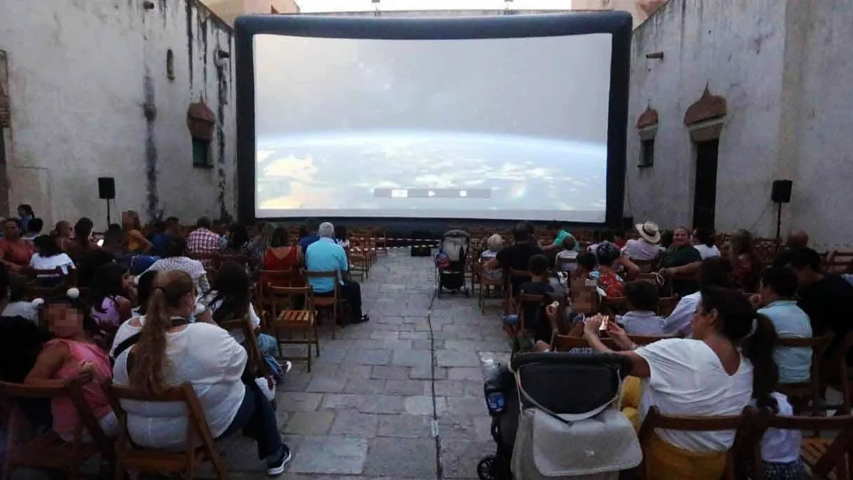 Pantalla de cine y público sentado en el Castillo de San Romualdo en San Fernando.
