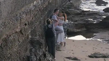Pareja vestida de novios sobre las rocas de La Caleta, en Cádiz, durante una sesión de fotos en el paseo Fernando Quiñones.