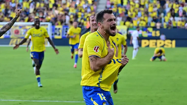 Tabatadze celebra el gol del triunfo ante el Albacete mientras los jugadores del Cádiz se acercan a felicitarlo y se ve a Mario Climent en el suelo festejándolo al fondo