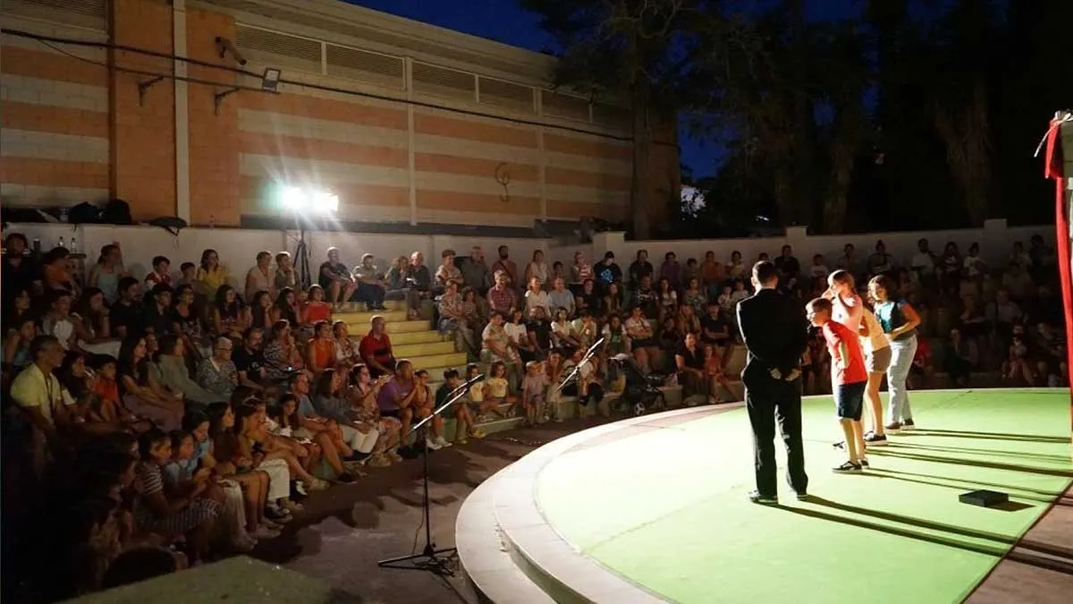 Escenario de teatro al aire libre en Rota con niños en el mismo.