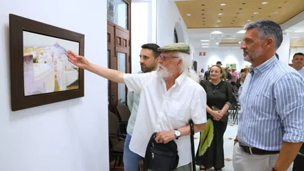 Tosar Granados, con camisa blanca, explicando un cuadro de la exposición.