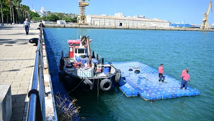 Operarios trabajando en la rehabilitación de un pantalán en el Paseo de Astilleros de Cádiz, preparativos para la Globe 40.