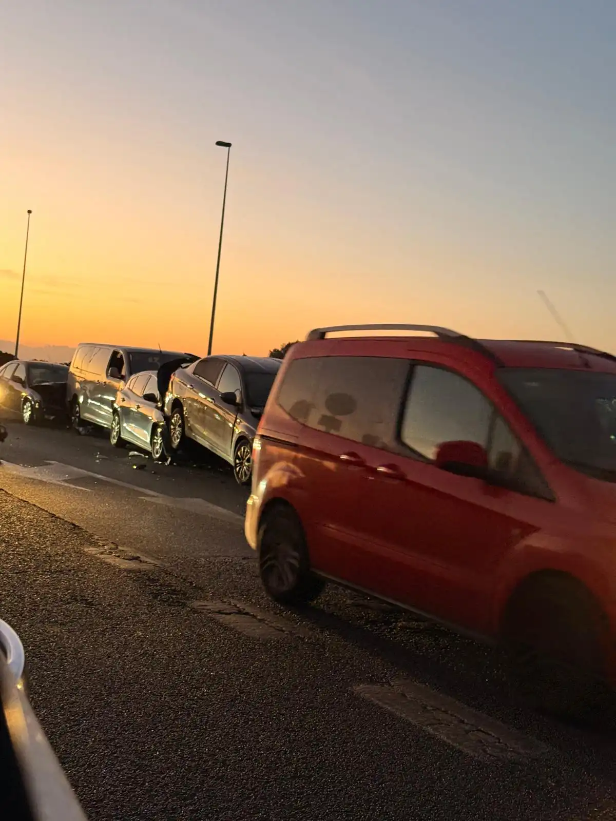 Imagen de la carretera en e lugar del accidente tomada por uno de los testigos. con un vehñicuo rojo circulando junto a algunos de los coches accdentados.