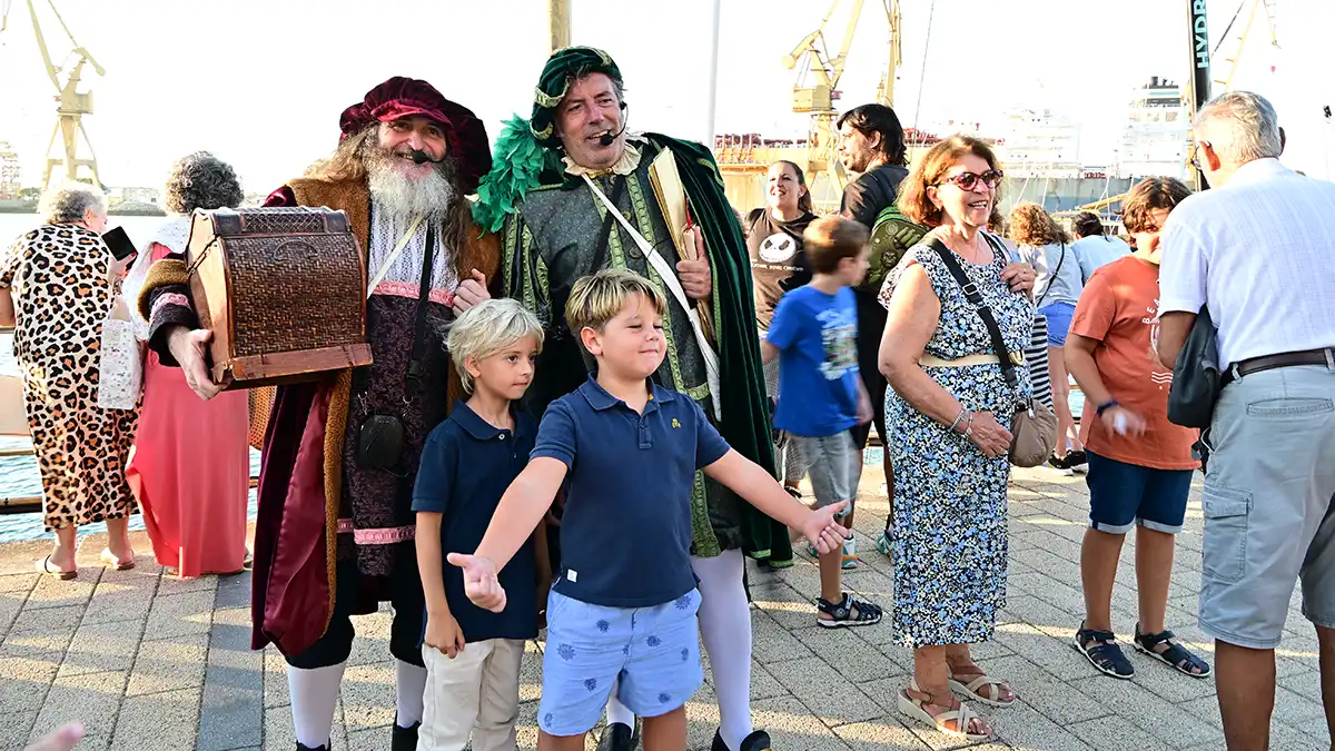 Dos niños posan con un grupo de animación en la Race Village