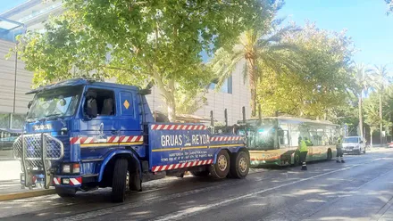 Grúa enganchando para posteriormente retirar un autobús urbano de Cádiz averiado en la parada del Hotel Atlántico de Cádiz.