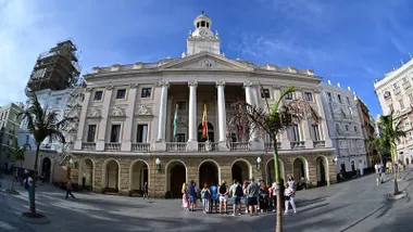 Fachada del Ayuntamiento de Cádiz con un grupo de turistas observándolo.