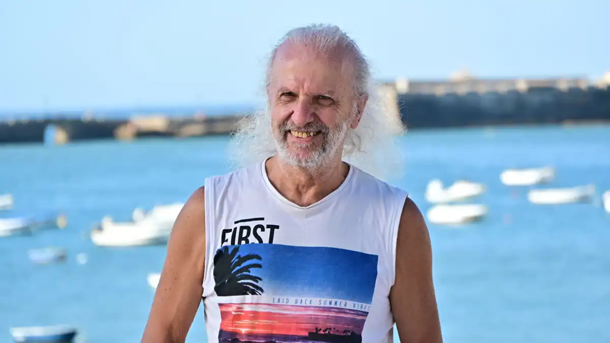 El guitarrista posa en enn camiseta sin mangas y pantalón corto.