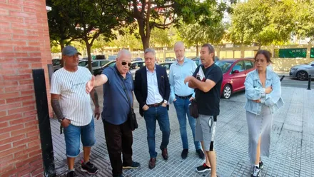 El presidente de la Asociación de Vecinos Bahía Gaditana, Gonzalo Pando, guía a un grupo de personas en una visita a la Barriada de la Paz del secretario del PSOE de Cádiz, José Ramón Ortega, y el portavoz municipal socialista, Óscar Torres