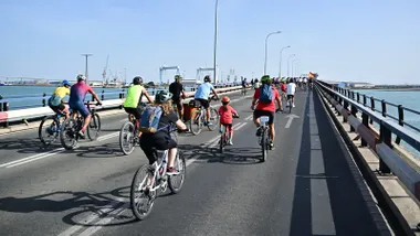 Un grupo de personas, entre ellos varios niños y niñas, pedalean por el Puente Carranza durante la bifestación en la que se pidió un carril bici