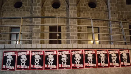 Varios carteles pegados en un muro del Paseo del Vendaval de Cádiz, con la imagen de Benjamin Netanyahu dibujado con bigote de Hitler y el texto “asesino de guerra”. Al fondo, parte de la fachada de la Casa de Iberoamérica.
