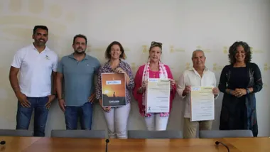 Fuerzas municipales y organizadores sostienen en sus manos el cartel del Día Mundial del Turismo en Chiclana.