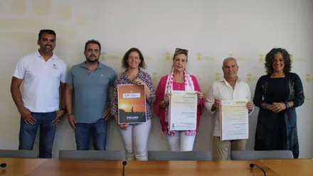 Fuerzas municipales y organizadores sostienen en sus manos el cartel del Día Mundial del Turismo en Chiclana.