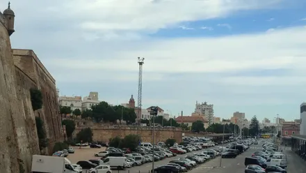 Fotografía del cielo parcialmente cubierto por nubes en Cádiz capital. En primer plano aparece la muralla histórica de la ciudad a la izquierda.