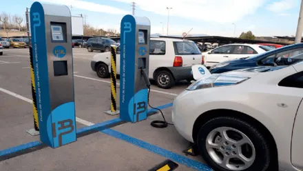 Surtidor de electricidad recargando un coche de color blanco.
