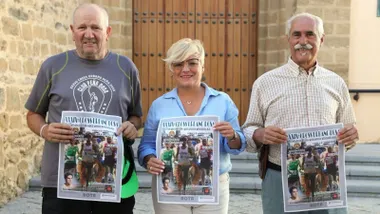 Organizadores, dos hombres y una mujer, sostienen el cartel del Cross de Rota en sus manos.