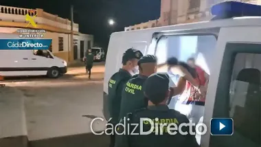 Detenido, con camiseta rosada, siendo introducido en el furgón de la Guardia Civil por varios agentes.